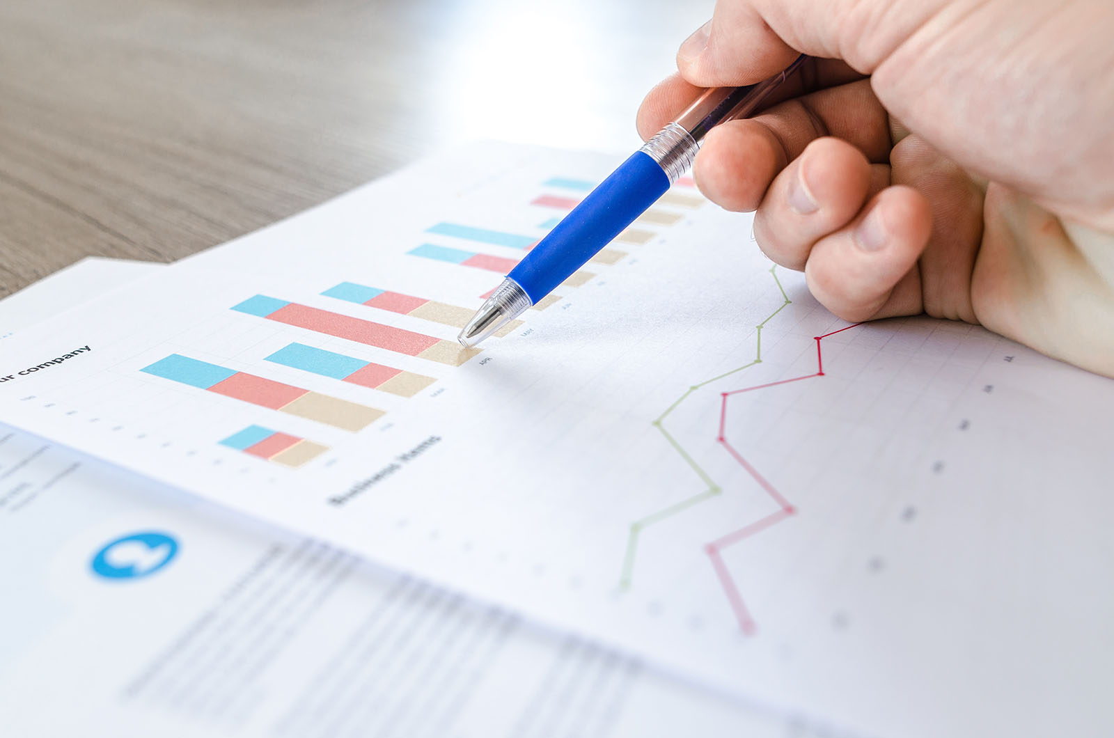 A hand pointing to data with a pen