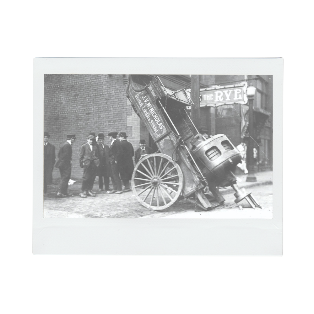Historical photo of Aim Transportation Solutions from 1914. A group of men are standing nearby a trailer with a large machine on the back.