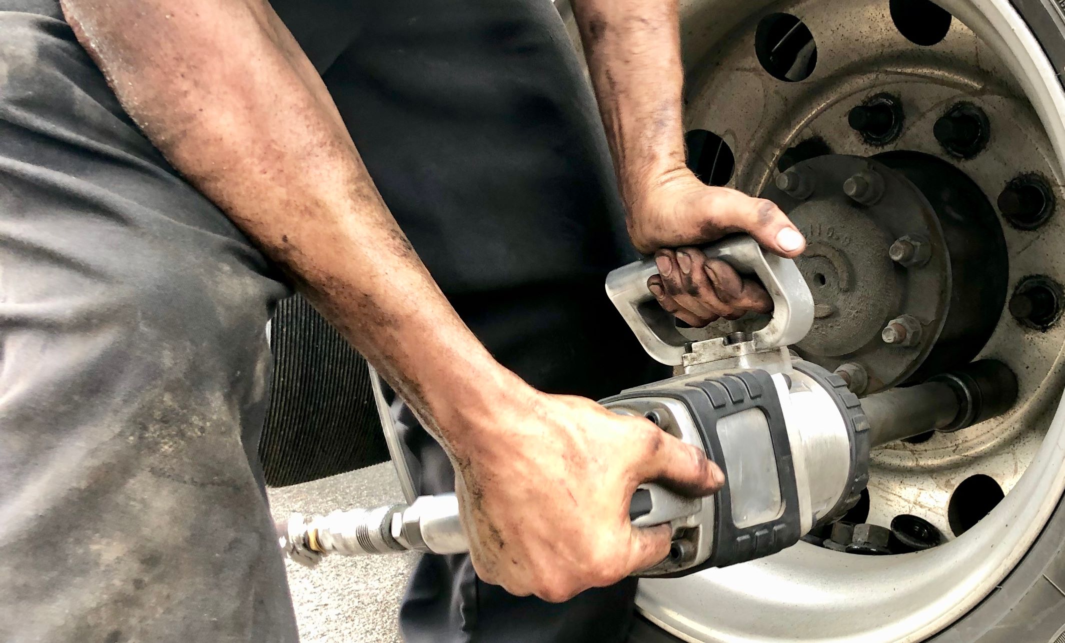 Mechanic using and impact wrench in a garage
